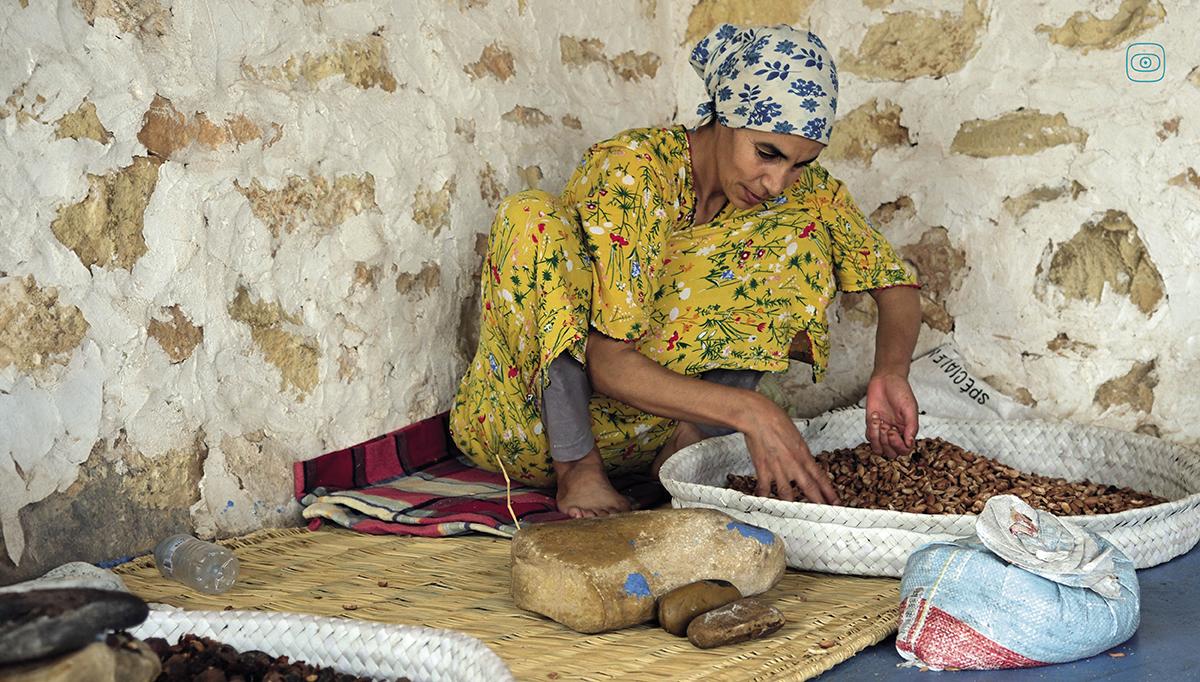 A woman crushes argan nuts by hand to retrieve the precious kernel, Co-op Ayadi Chiadma, Morocco.