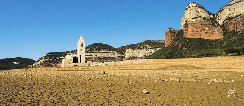 Sau Reservoir in Catalonia, now empty. Dry landscape, blue skies