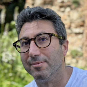 a man with short hair wearing glasses